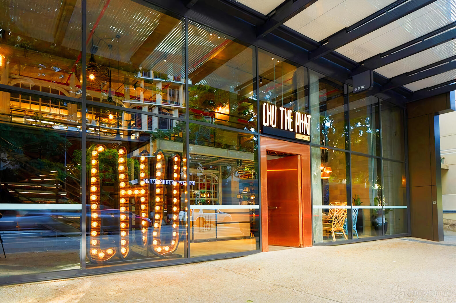 A restaurant with a glass facade, marquee lights, and visible indoor seating at Chu The Phat.