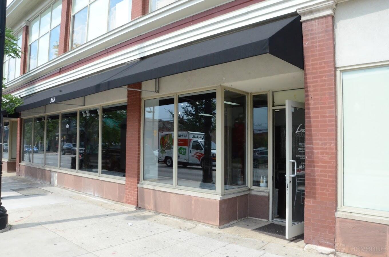 A versatile event space with large glass windows and a black awning at Luxe B Studio.