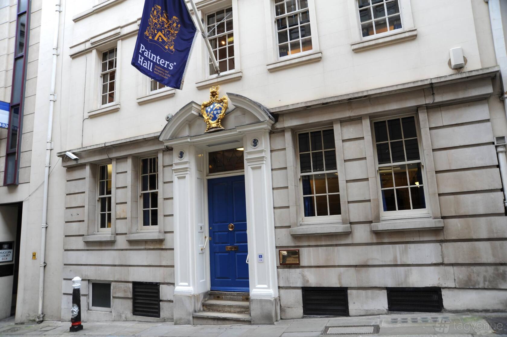 A historic building with a blue door, white columns, and decorative crest at No.9 Little Trinity Lane.