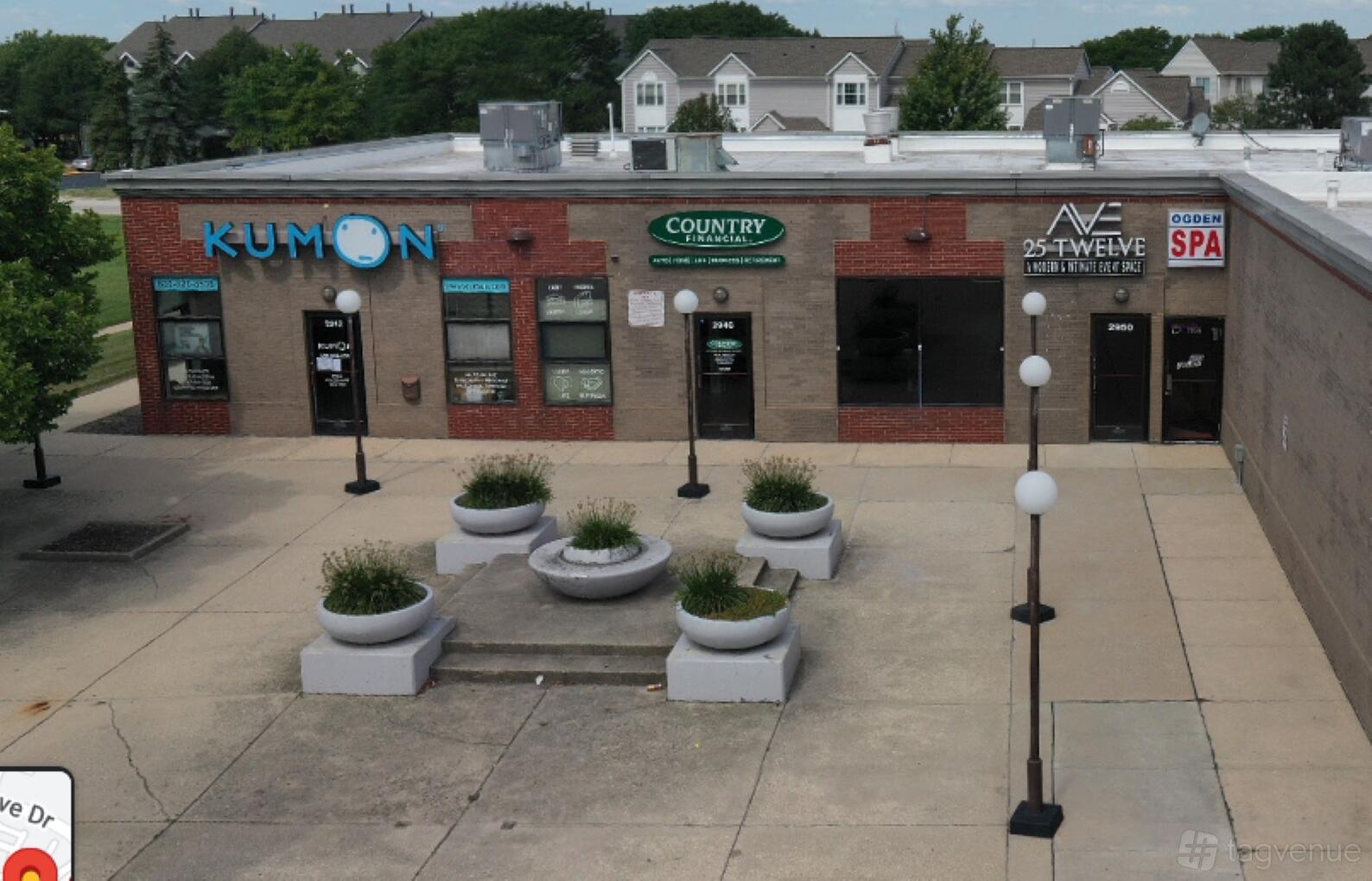A versatile event space with a paved courtyard, large planters, and bench seating at Ave 25 Twelve.