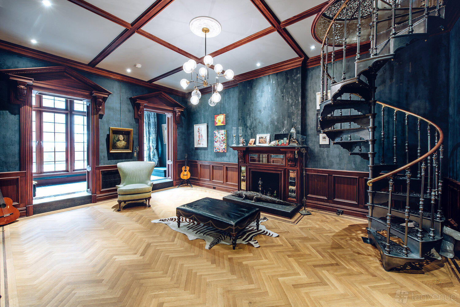 An event venue with herringbone wood floors, a spiral staircase, and a fireplace at Ideal Glass Studios.