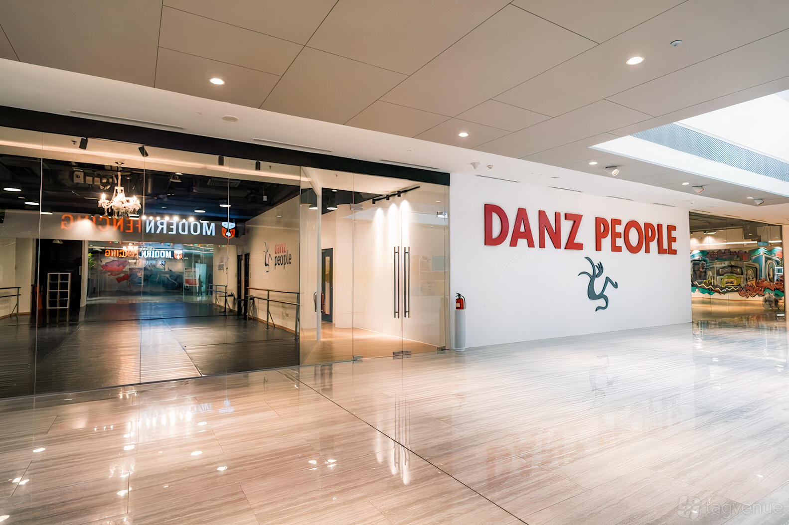A dance studio with floor-to-ceiling glass walls, a spacious entrance, and signage at Danz People.