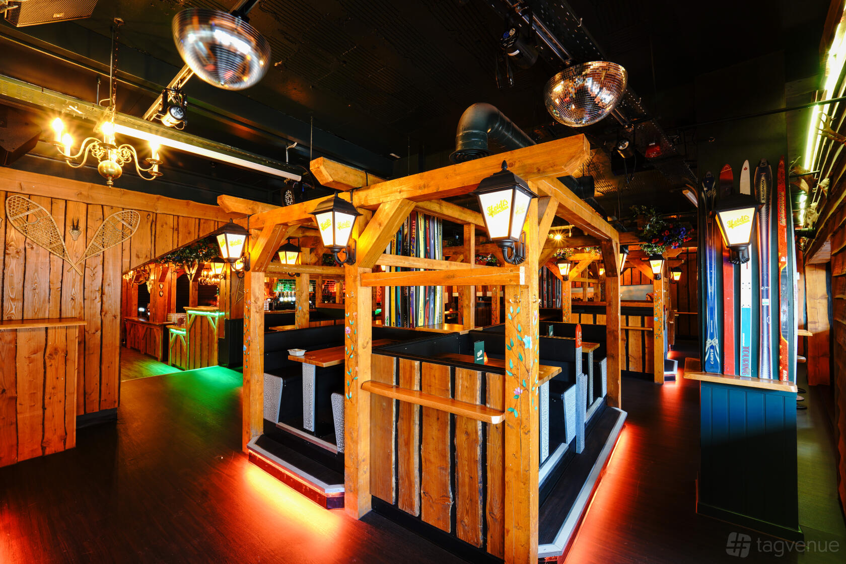 A rustic bar with wooden booths, lantern lighting, and decorative skis at Barbara's Bier Haus Birmingham.