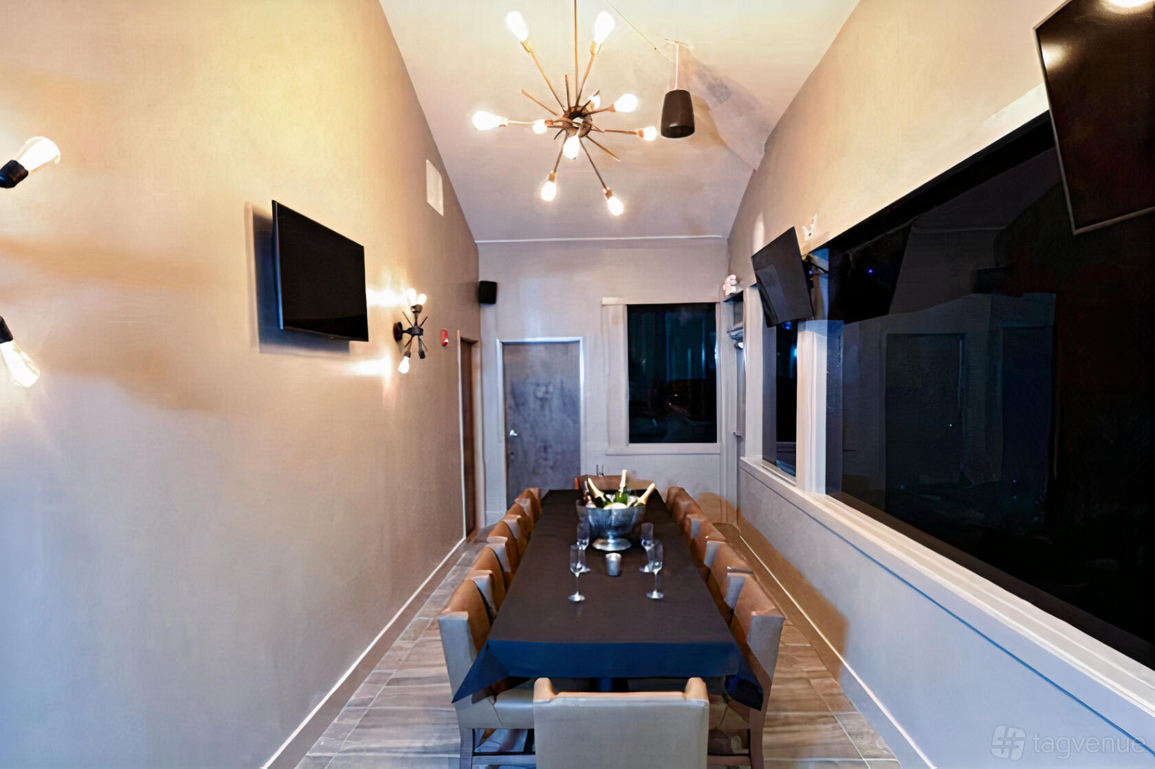 A private dining room with a long table, tan chairs, and modern light fixtures at Clutch.