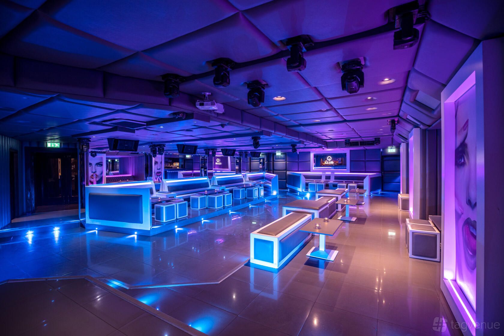 An underground event space with neon lighting, glossy floors, and booth seating at Q Shoreditch.