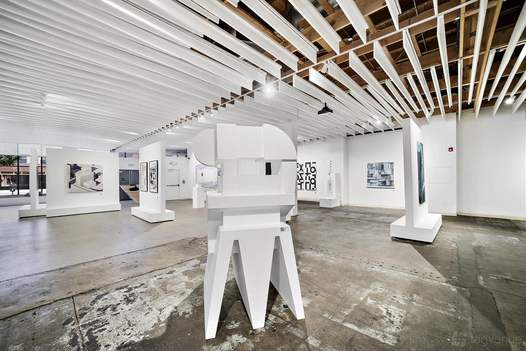 An event venue with contemporary art sculptures, concrete floors, and exposed wood ceiling beams at Temple Denver.
