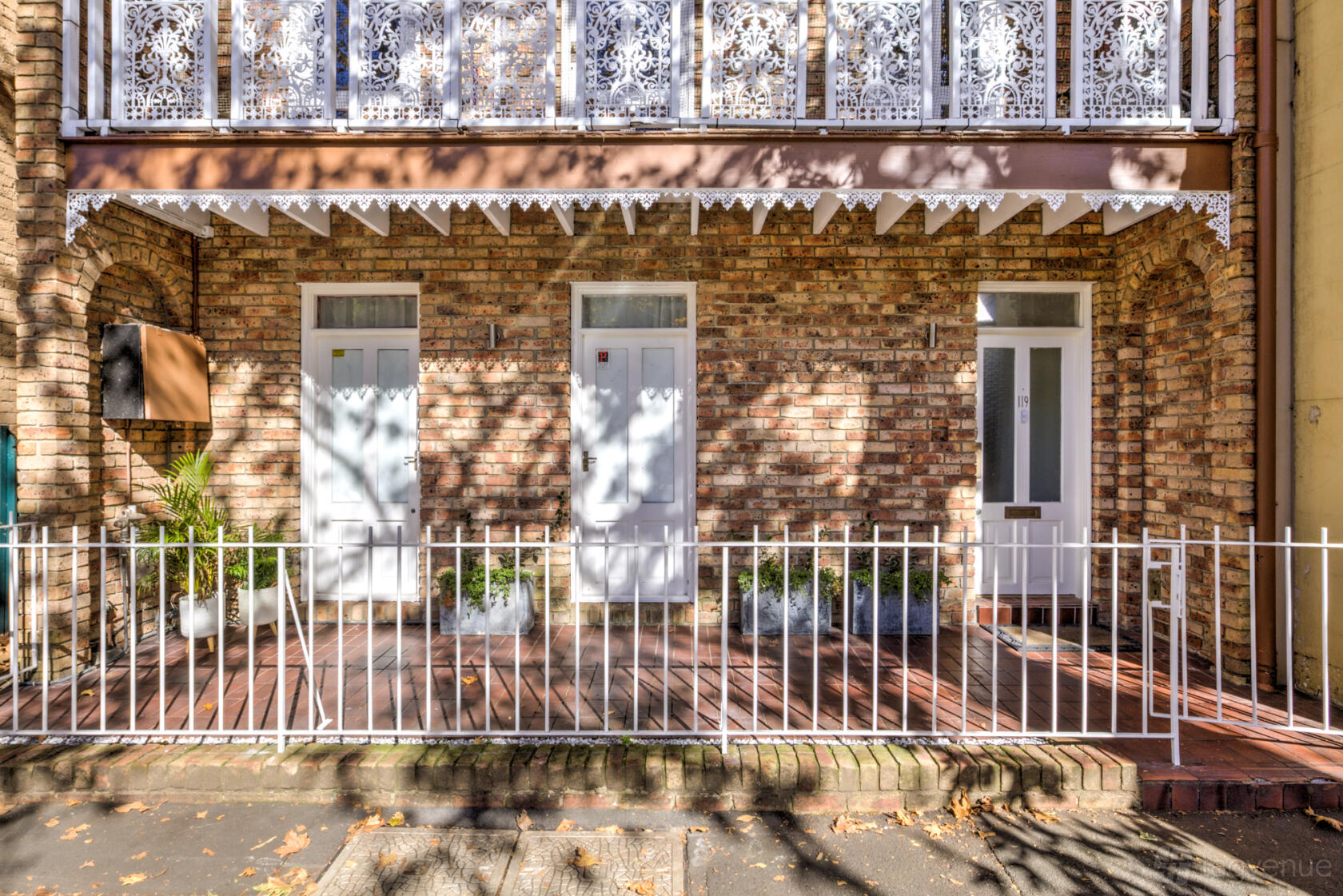 A film and photo studio with a brick facade, white trim, and decorative ironwork balcony at Marmalade Studio.