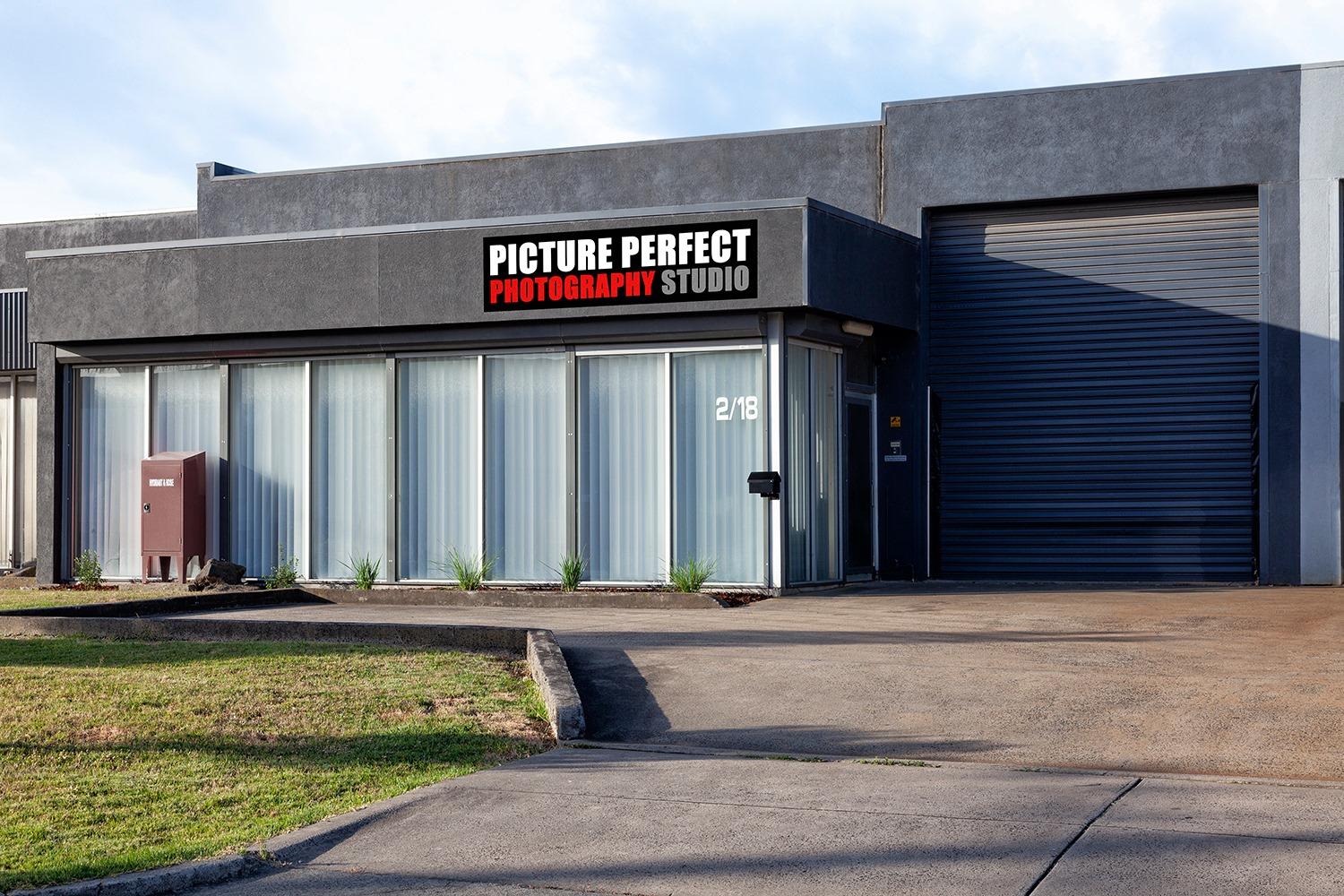 A film and photo studio with a modern grey facade, large front windows, and a roller door at Picture Perfect Photo Studio.