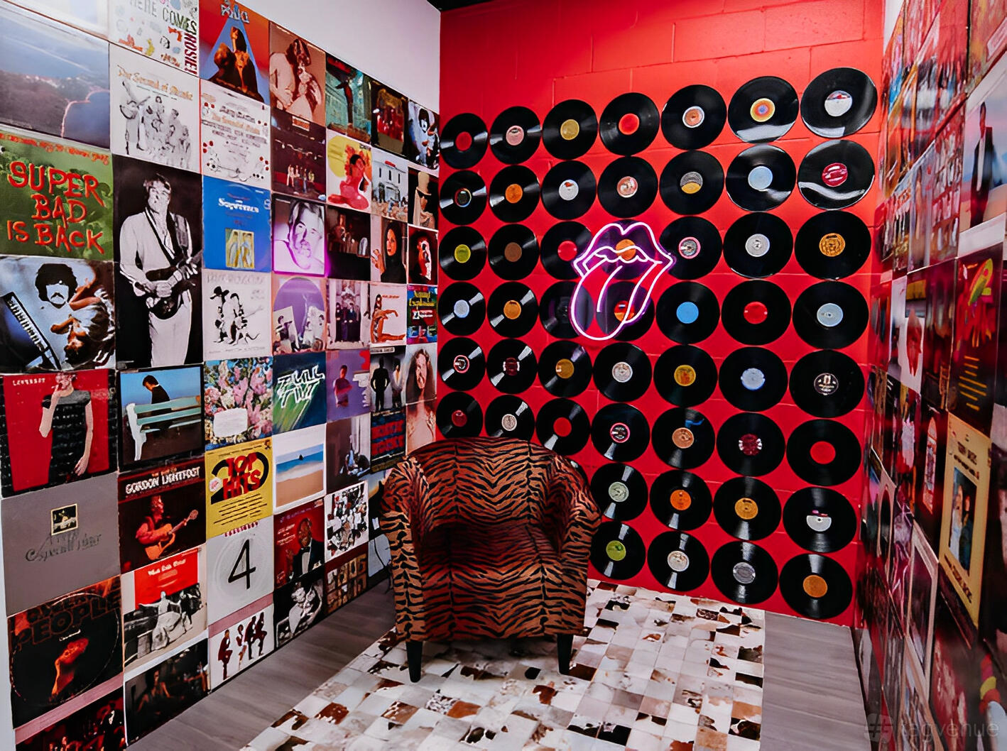 An event space with a wall covered in vinyl records, album covers, and a zebra print chair at Abstract Productions House.