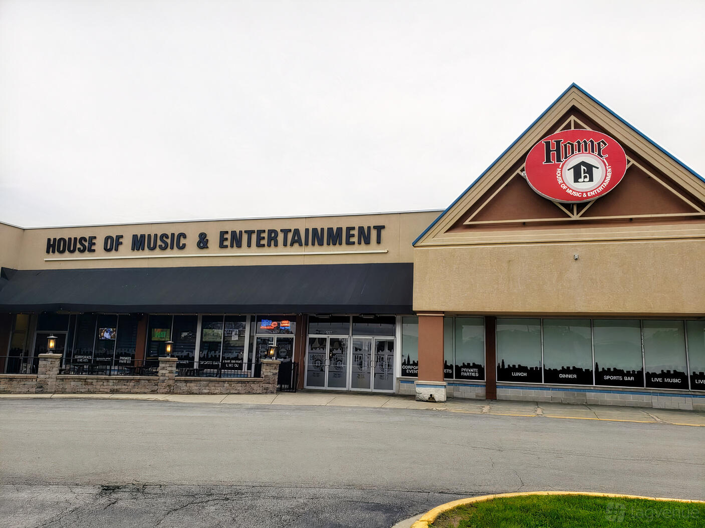 A pub with a large storefront featuring bold signage and awnings at House of Music & Entertainment (HOME Bar).