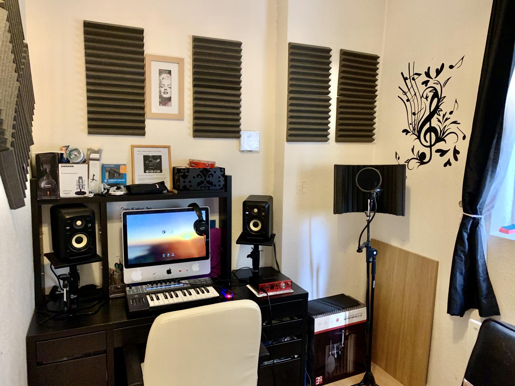 A podcast studio with soundproofing panels, a microphone with pop filter, and music-themed wall art at Xtina Studio.