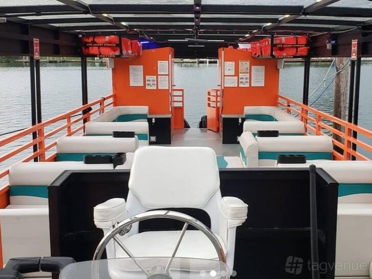 A yacht with cushioned bench seating, open sides, and an uncovered helm area at Ocean View Yacht Charters.
