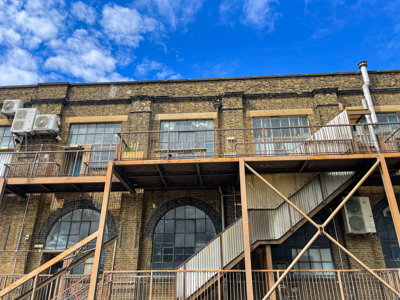 A film and photo studio with large industrial windows and an exterior metal staircase at Crixus Studios.