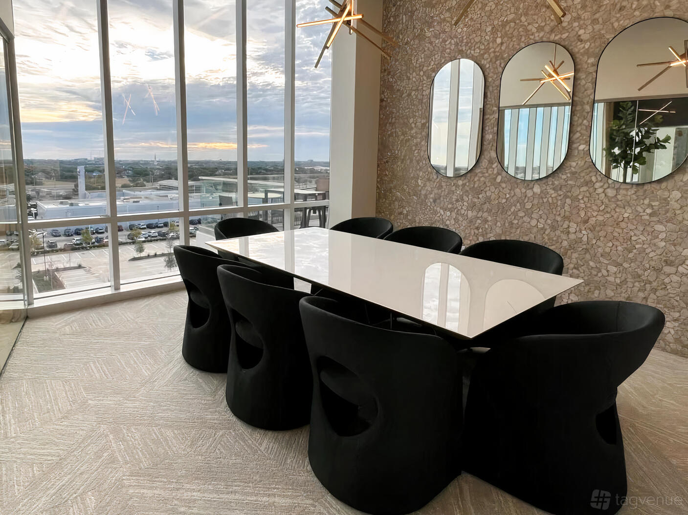 A coworking boardroom with a marble conference table, black chairs, floor-to-ceiling windows, and wall mirrors at Lucid Private Offices - West Plano.