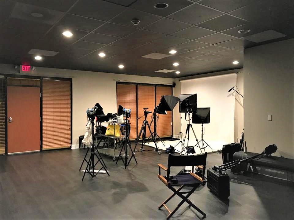 A recording studio with lighting equipment, backdrop, and musical instruments set up at McPhail Studios.