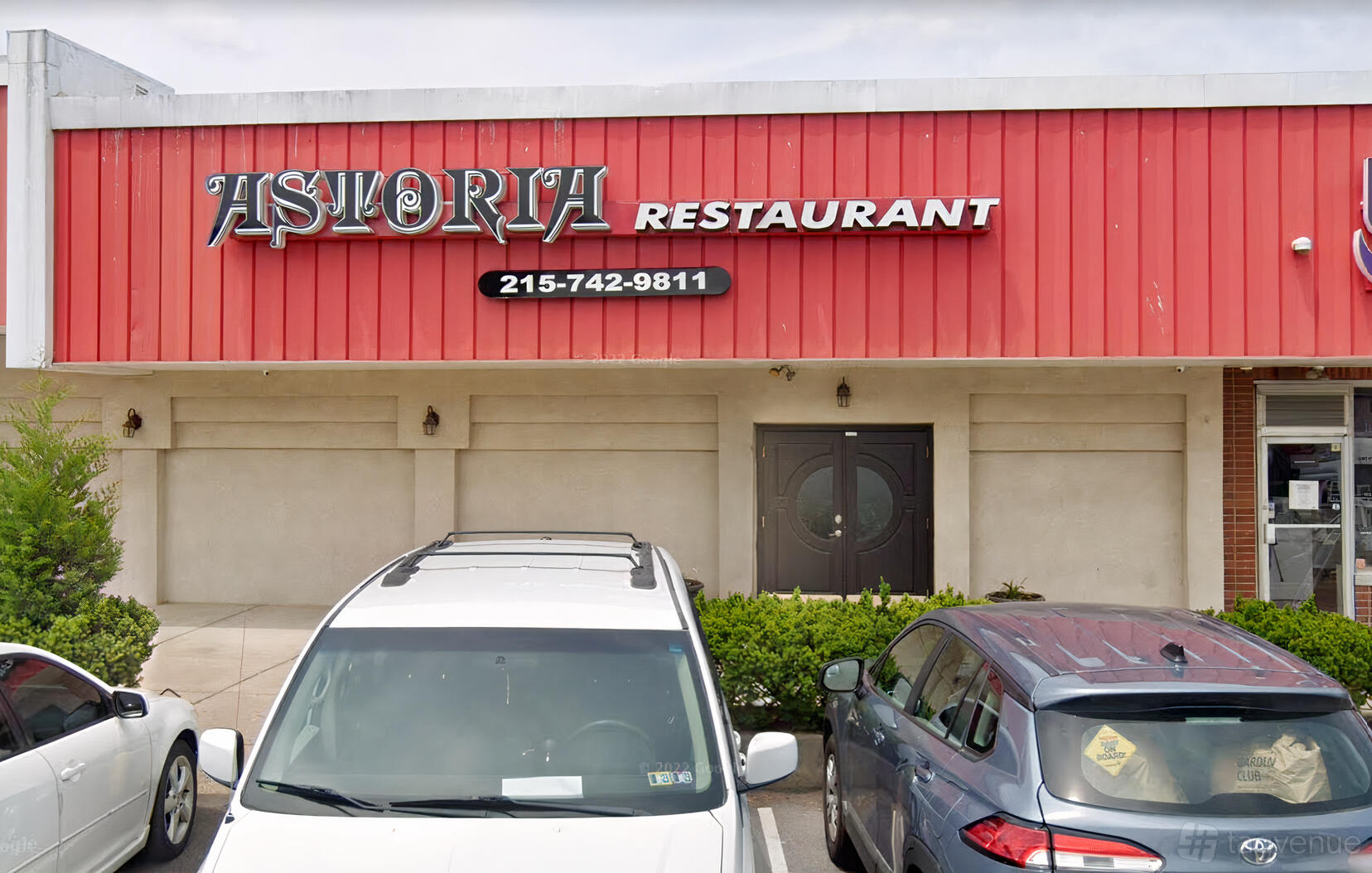 The exterior of Astoria Restaurant and Catering with a red facade, bold signage, and double entry doors.