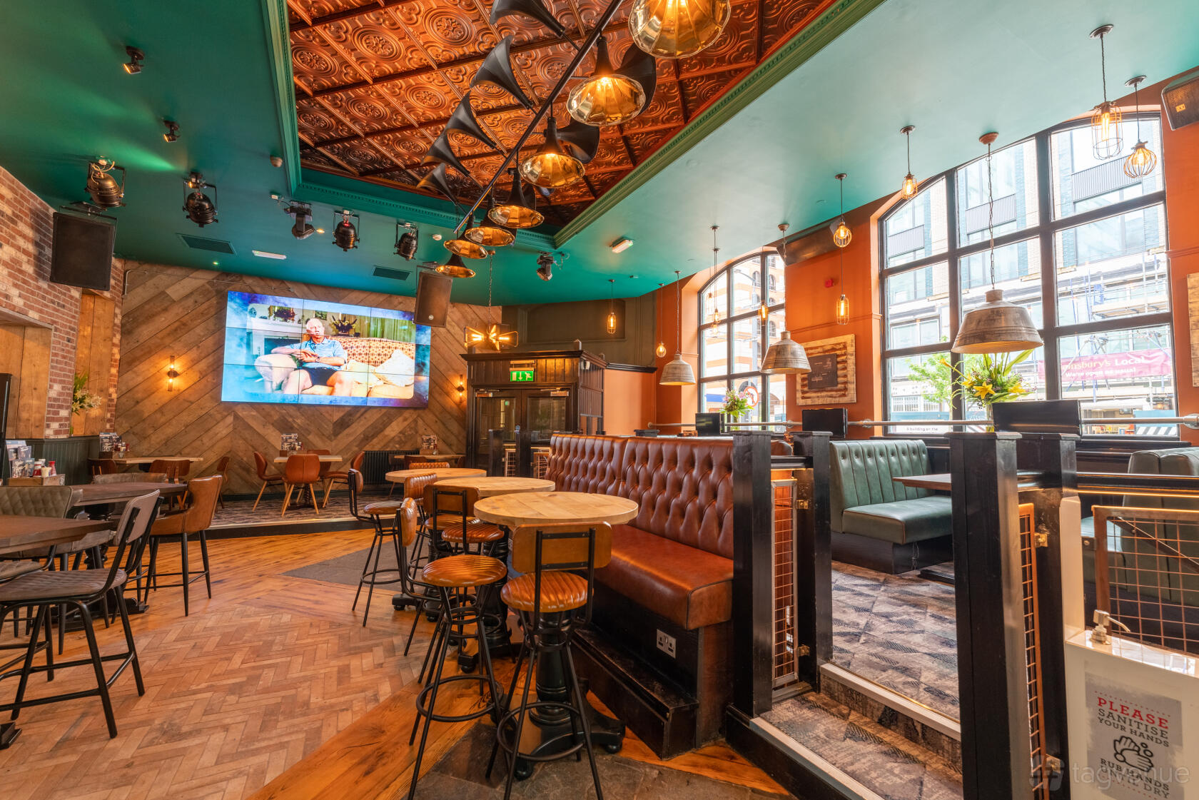 A pub with tufted leather banquettes, wooden tables, and large street-facing windows at O'Neill's Broad Street.