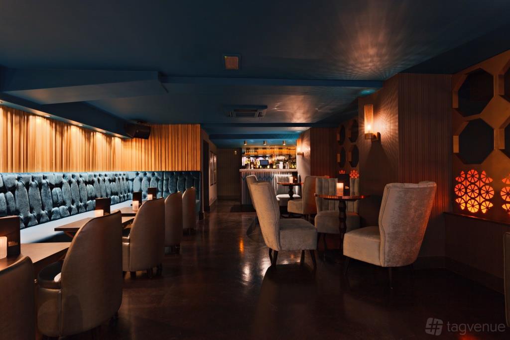A function room with plush velvet seating, warm lighting, and patterned wall panels at Dirty Martini St. Paul's.