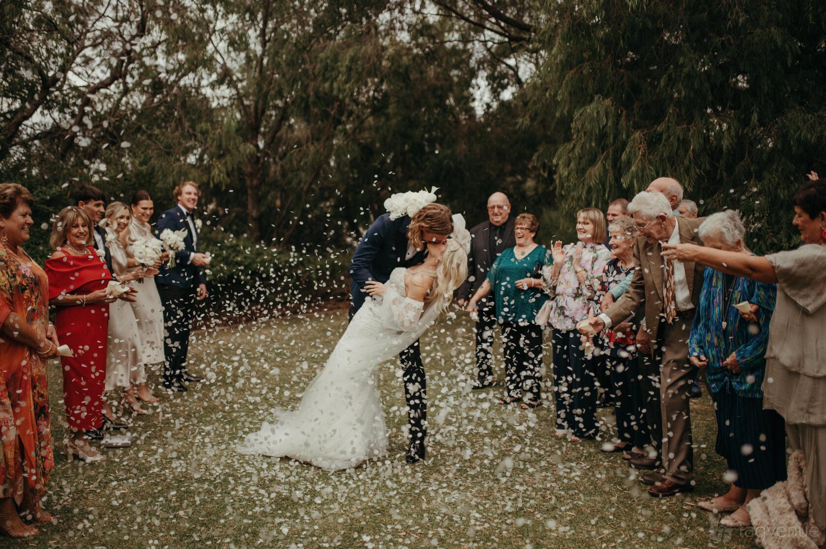 An outdoor amphitheatre surrounded by greenery and guests tossing flower petals at Pullman Bunker Bay.