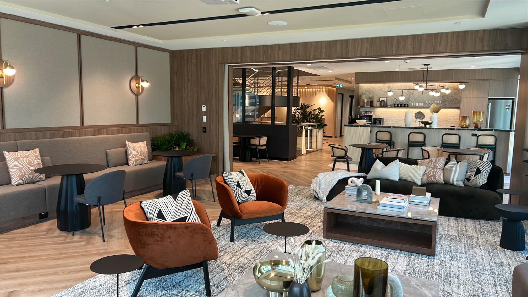 An event venue with lounge seating, patterned cushions, and a bar area at JustCo at King Street.