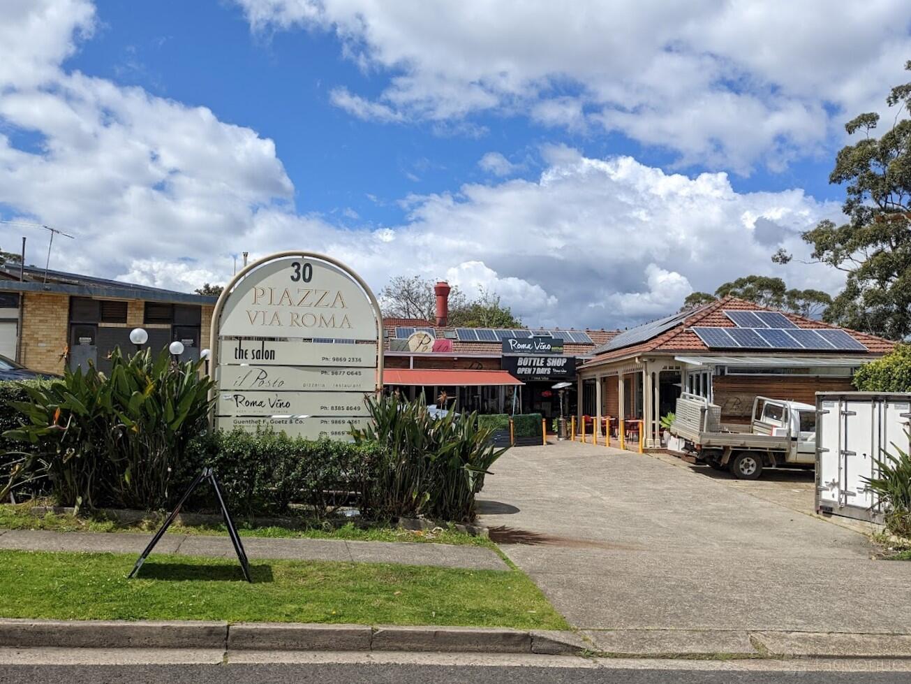 A restaurant exterior with a prominent sign, tiled roof, and solar panels at Il Posto.