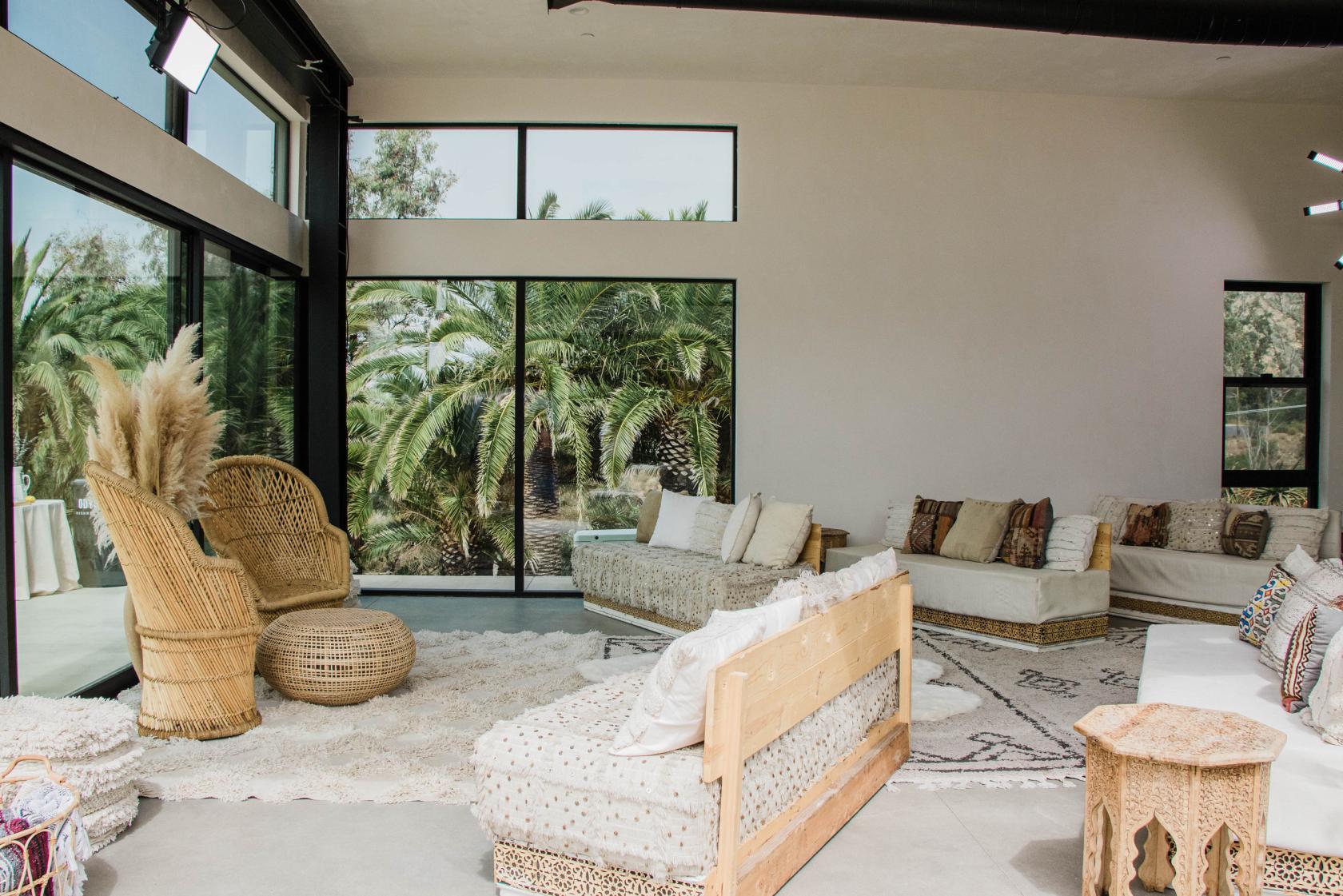 A yoga studio with large windows, natural light, woven seating, and neutral decor at Zuma Sanctuary.