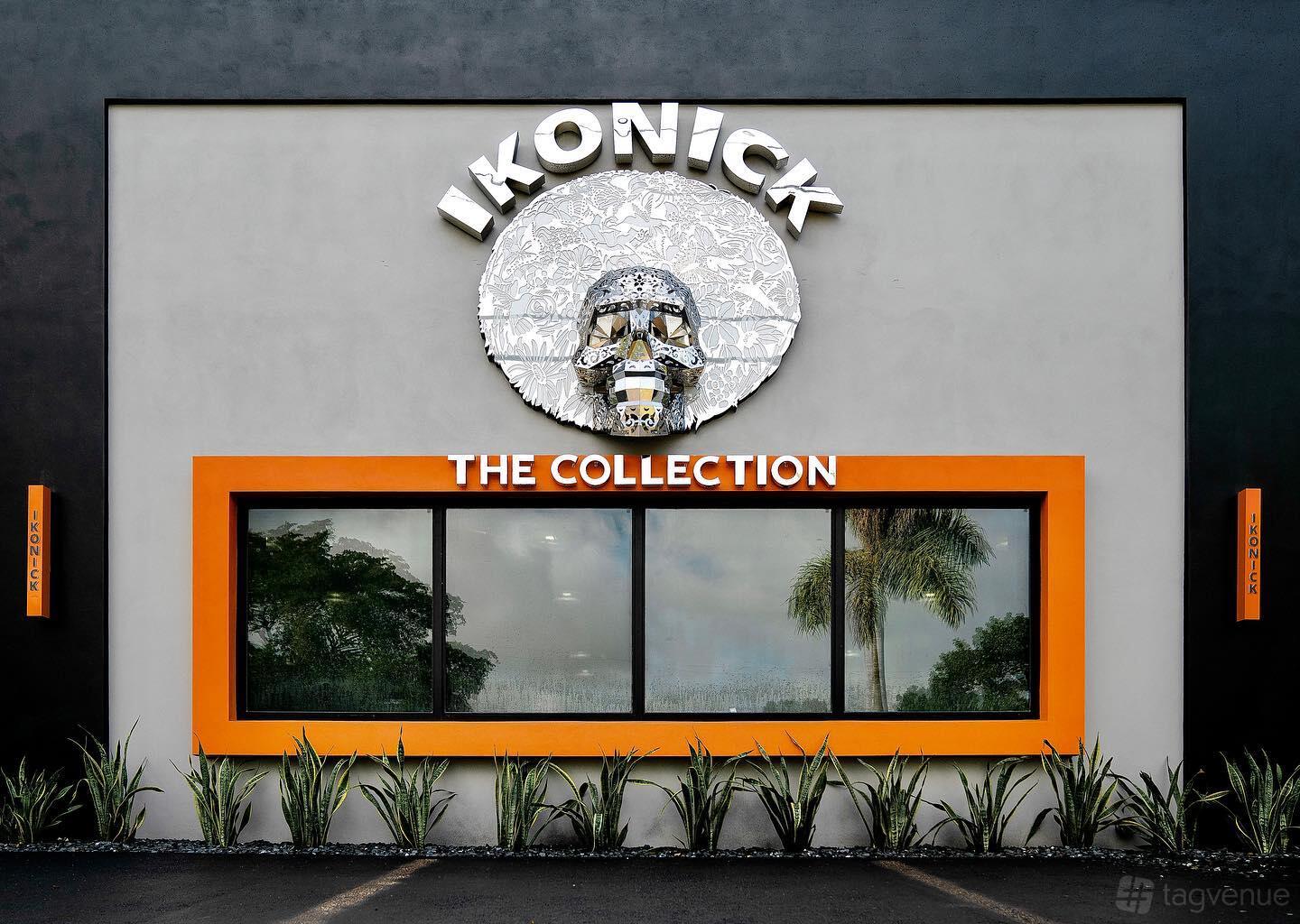 A versatile event space with a prominent logo sign, large window, and landscaped plants at Ikonick Collection.