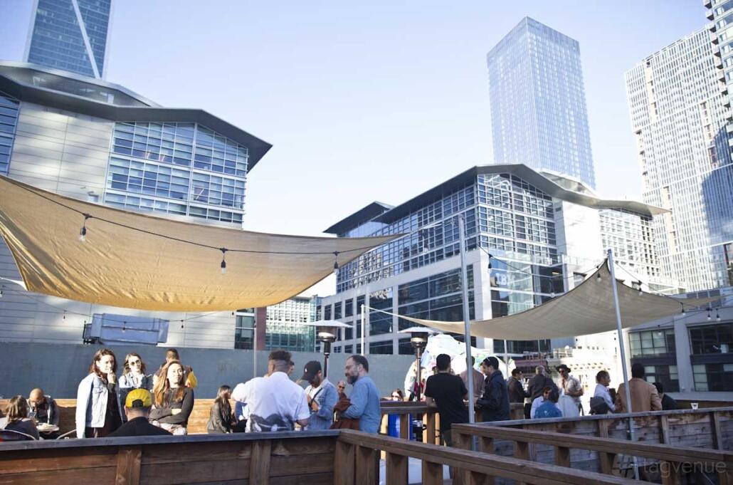 An event space with shade sails and wooden railings on a rooftop at Zen Compound's Mirus Gallery San Francisco.