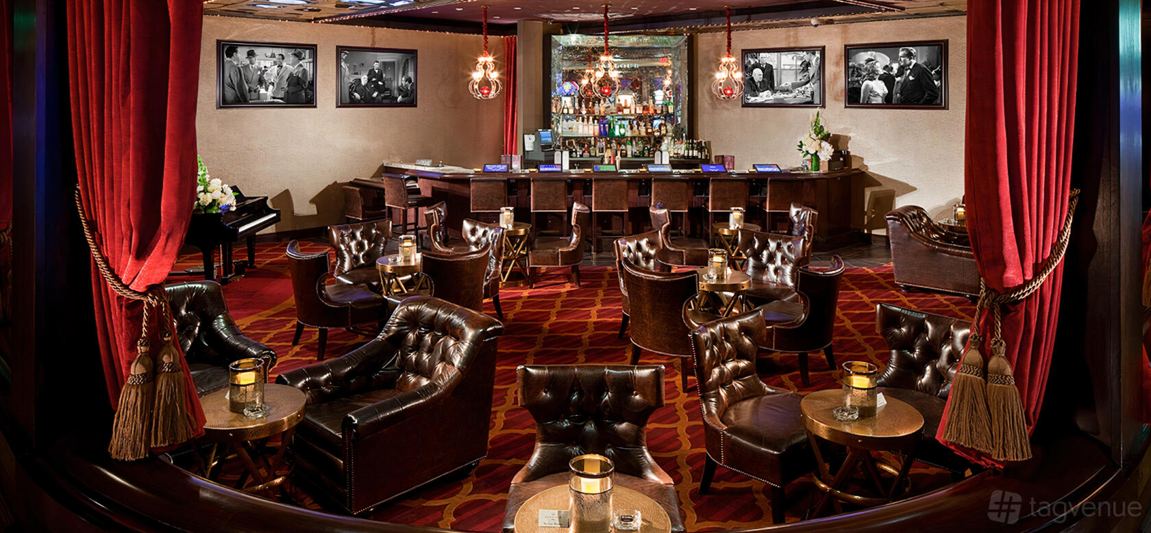 A hotel bar with leather armchairs, round tables with candles, vintage chandeliers, and a central bar at El Cortez Hotel and Casino.