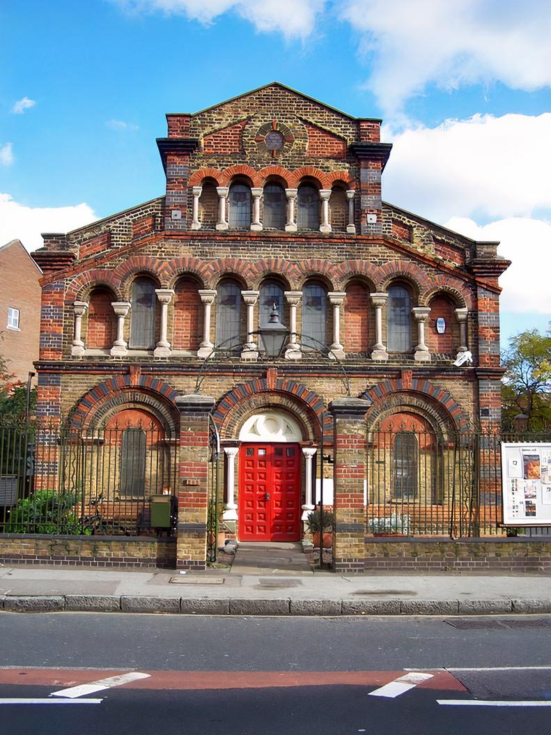 A versatile event space with arched windows and a red double door in a historic brick building at The Space.