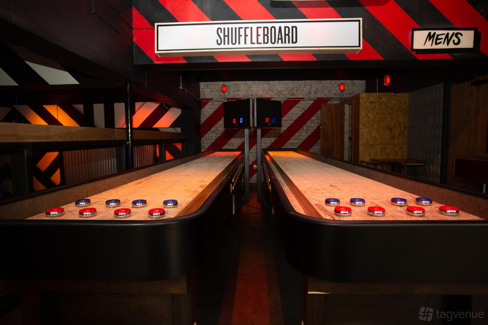 An event space in a bar with two shuffleboard tables under bold red and black wall accents at Roxy Ball Room Leeds Merrion Street.