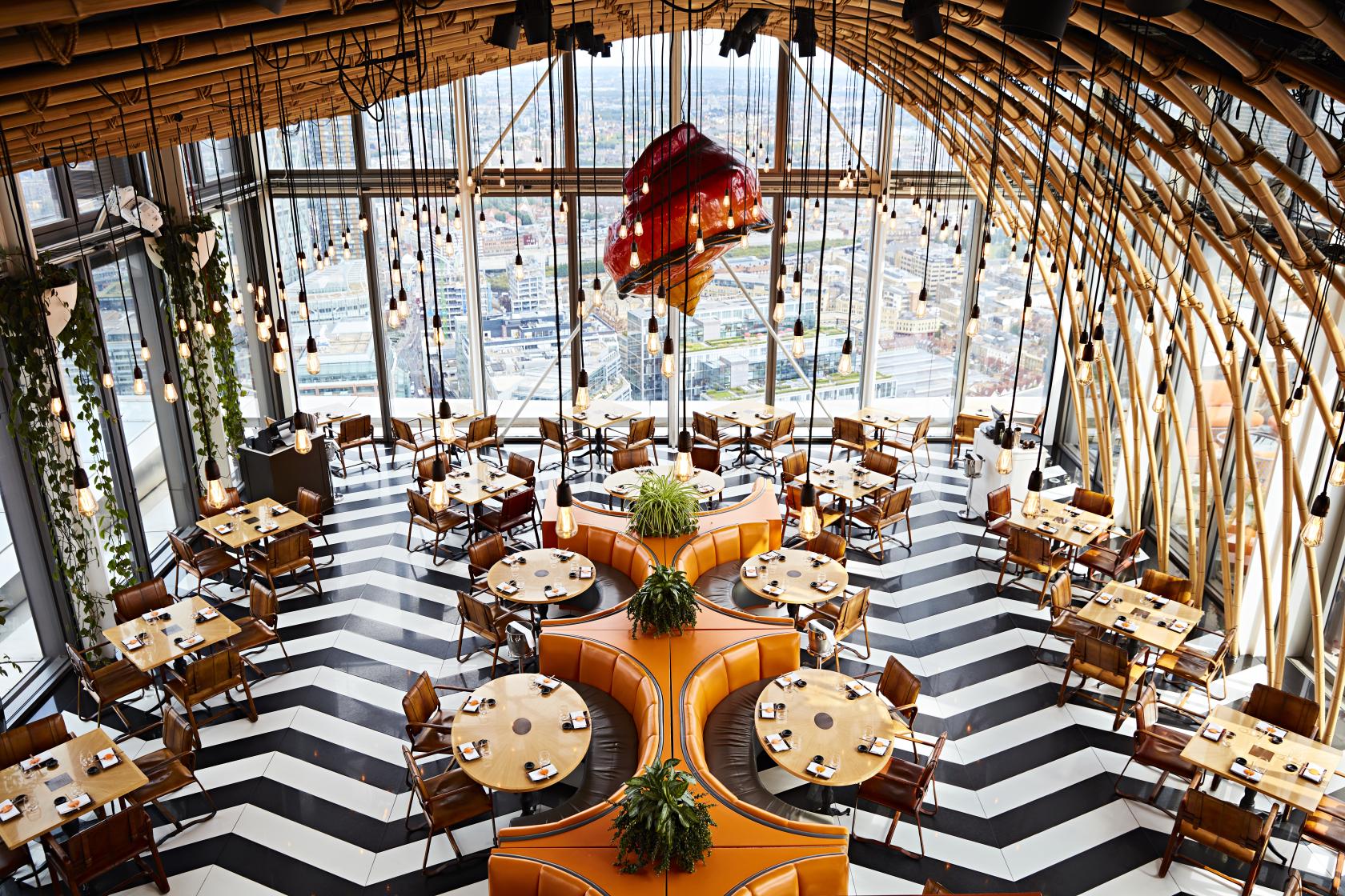 A restaurant with floor-to-ceiling windows, chevron flooring, and unique wooden ceiling arches at SUSHISAMBA.