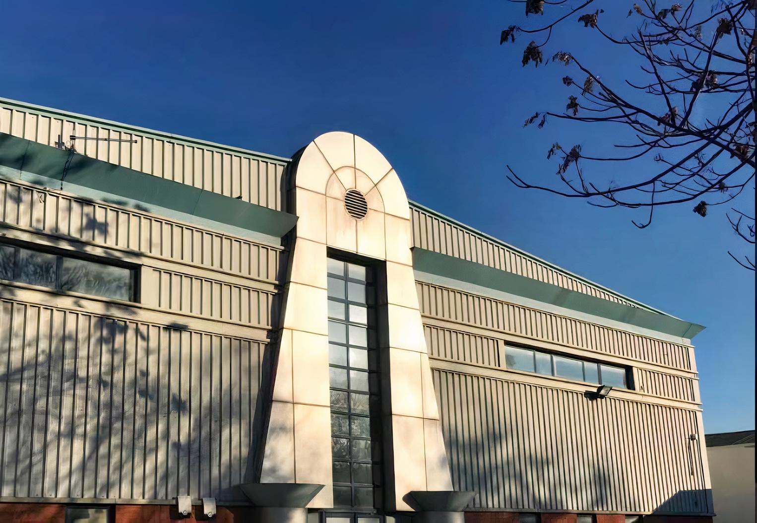 An event space with corrugated metal siding, large vertical windows, and art deco-inspired architecture at MAKE IT London.