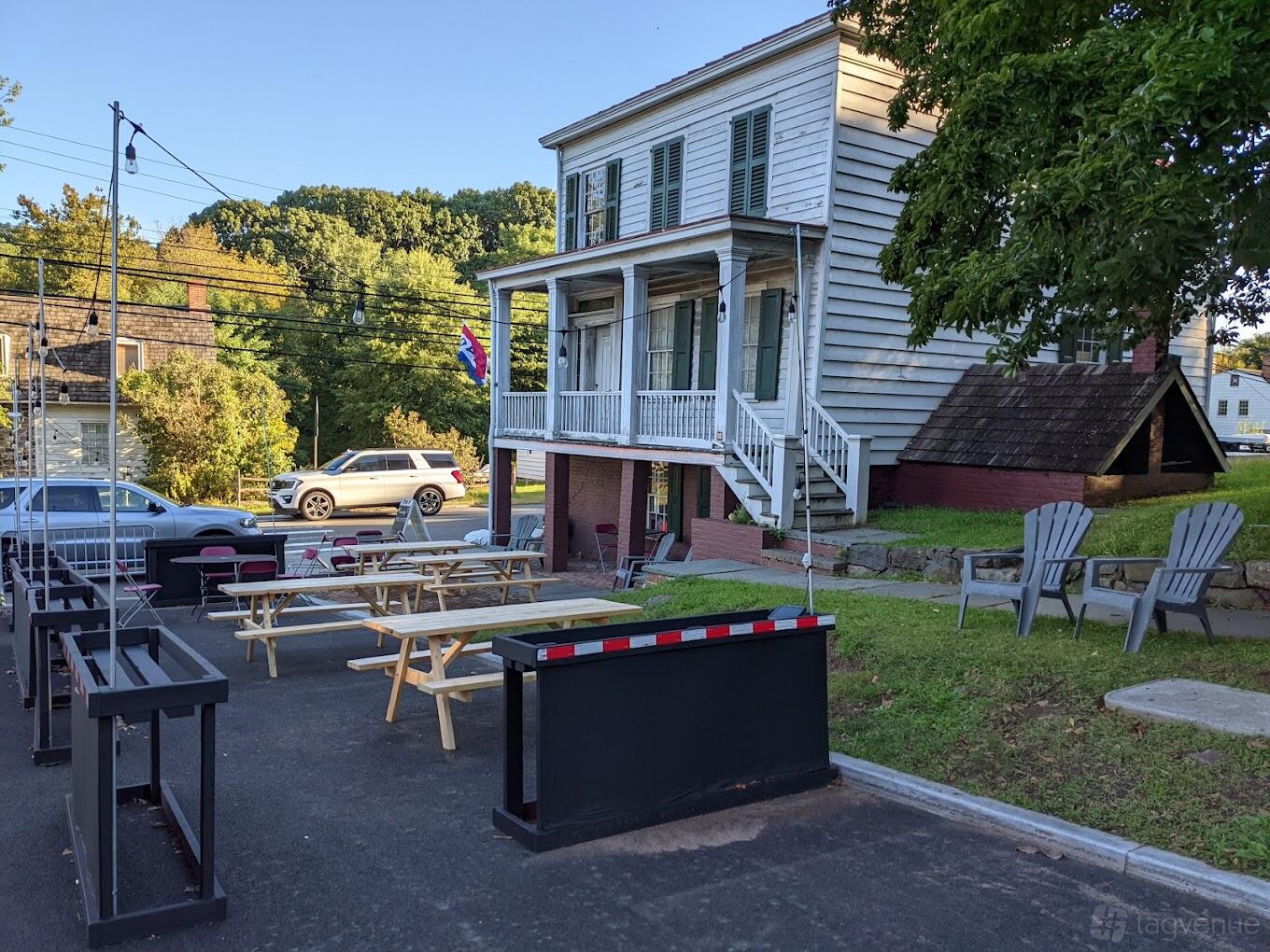 An outdoor cafe area with picnic tables, Adirondack chairs, and street views at Main Street Coffee.
