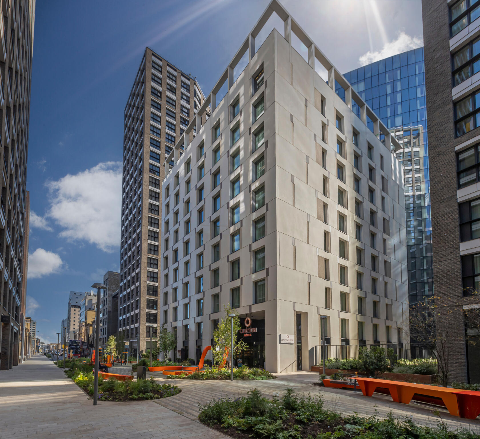 A modern hotel with a white geometric facade and street-level landscaping at Clayton Hotel City of London.