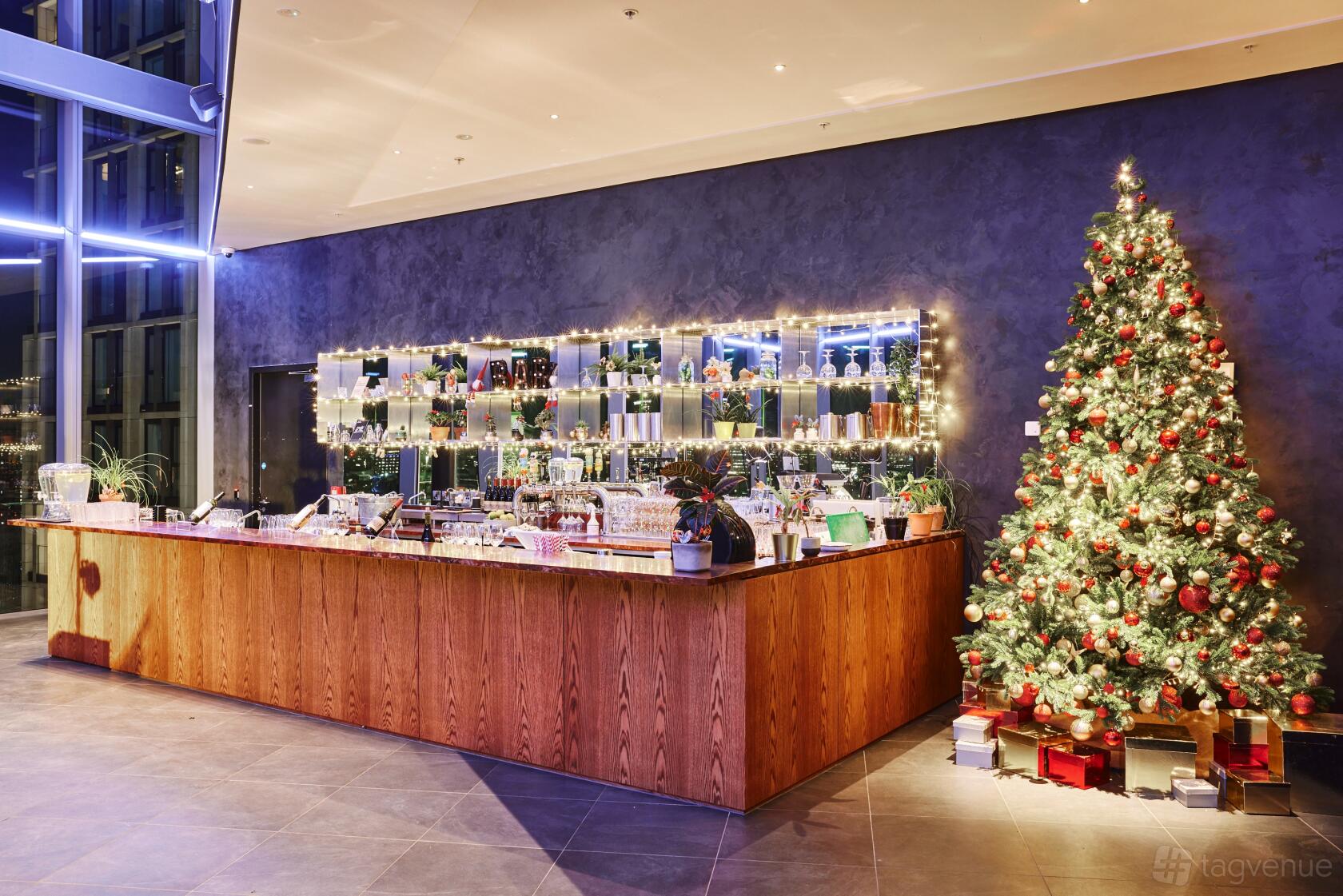 An event venue with a decorated bar featuring festive string lights and a Christmas tree at 10 York Road.