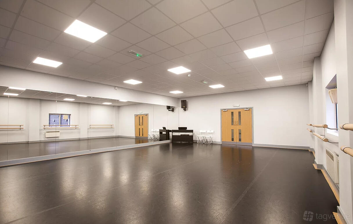 A dance studio with floor-to-ceiling mirrors, ballet barres, and a sound system at Adagio School Of Dance.