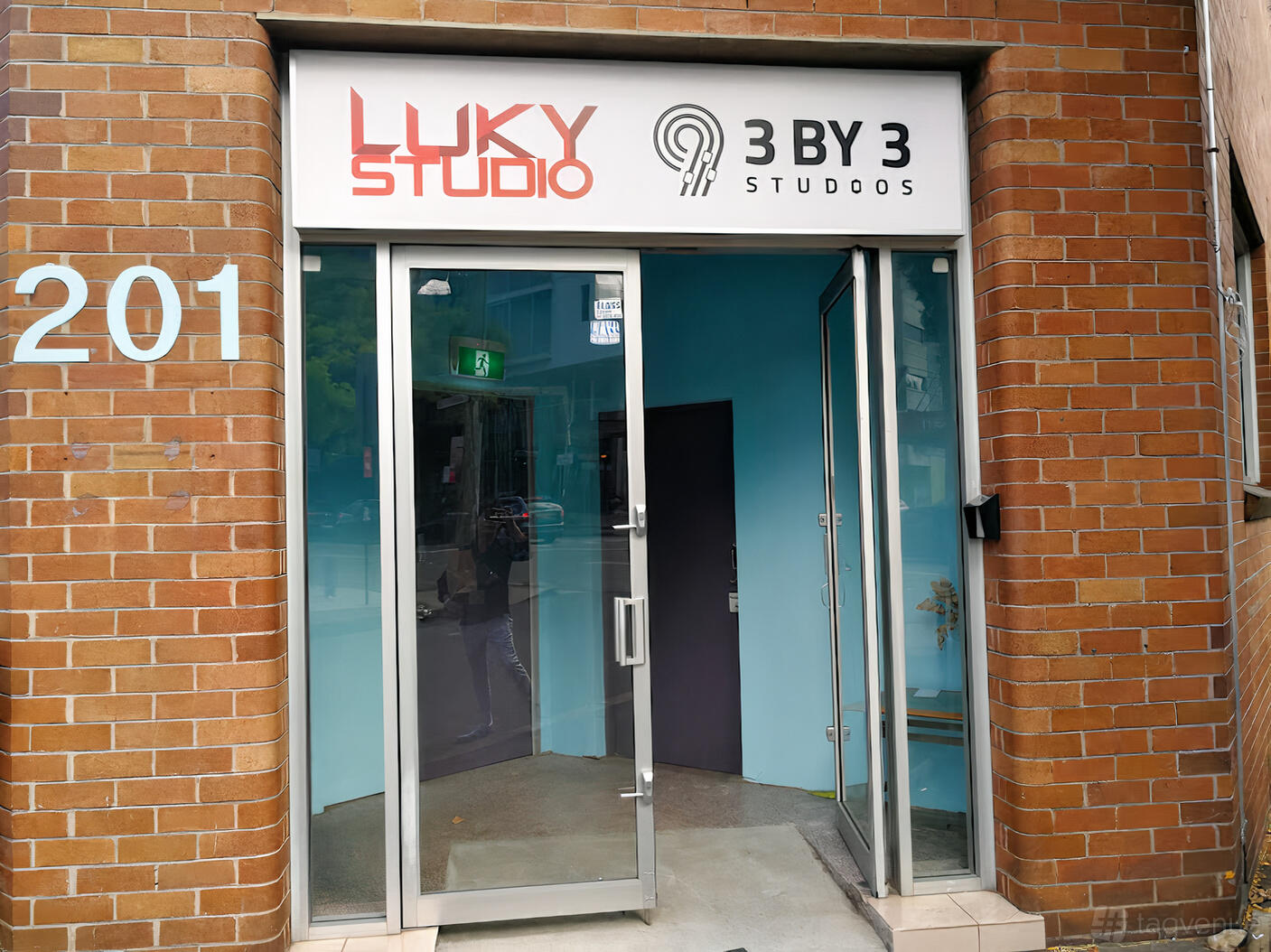 A film and photo studio with a glass door entrance and brick exterior at Luky Studio.