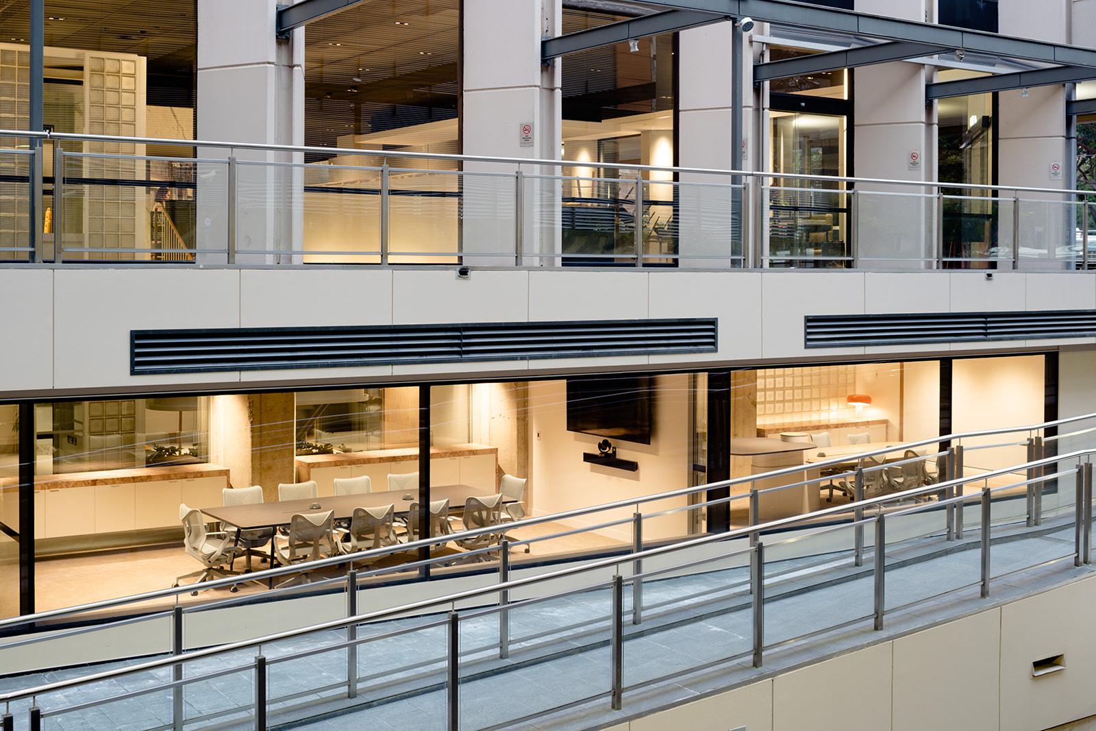 A meeting centre with floor-to-ceiling glass walls, conference tables, and ergonomic chairs at Centred.