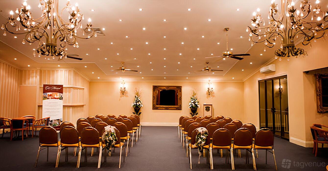An event venue with rows of chairs, chandeliers, floral arrangements, and a large mirror at Shafston House Weddings & Event.