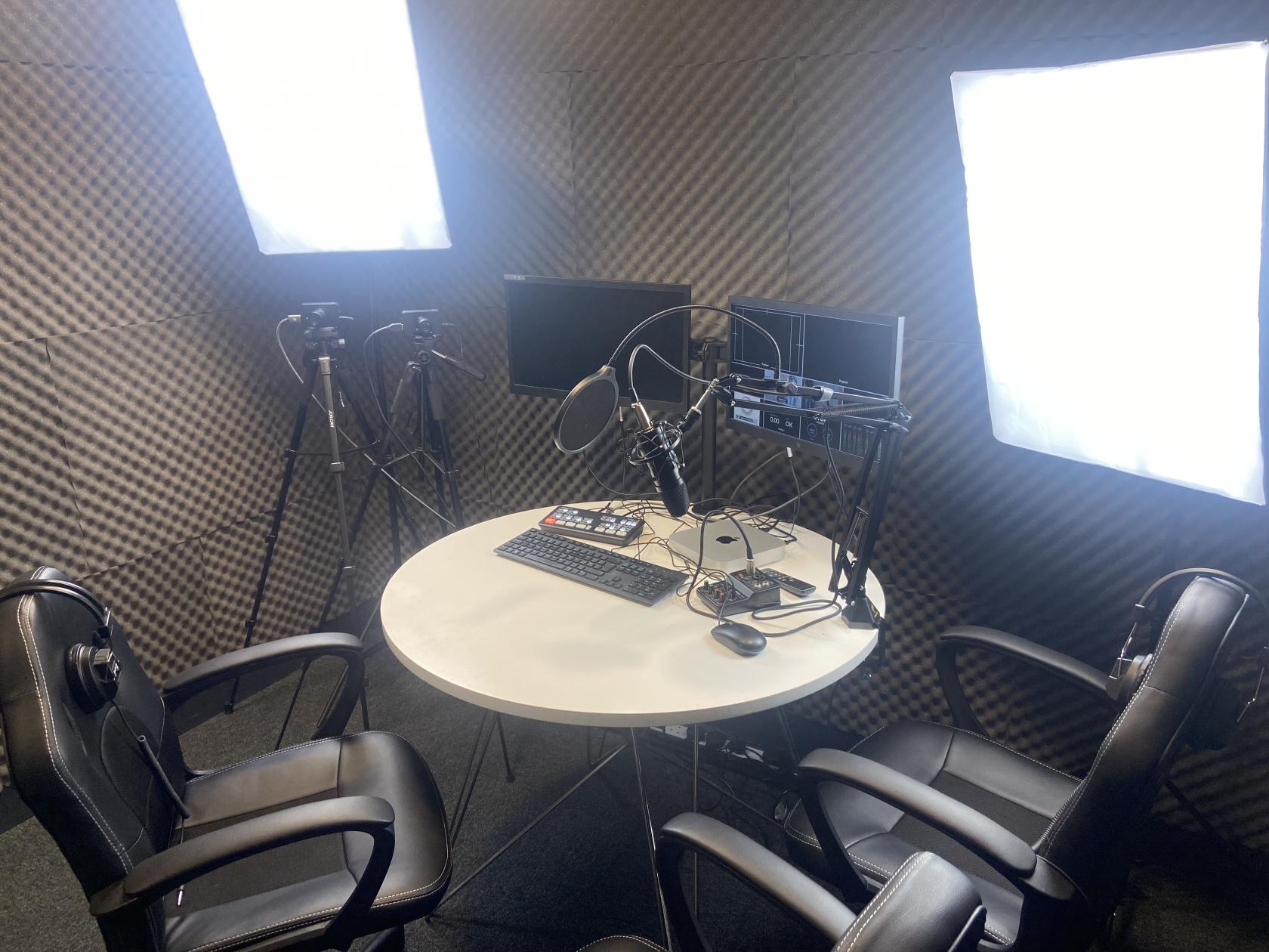 A soundproofed studio with recording equipment, microphones, and round table at Osmani Centre