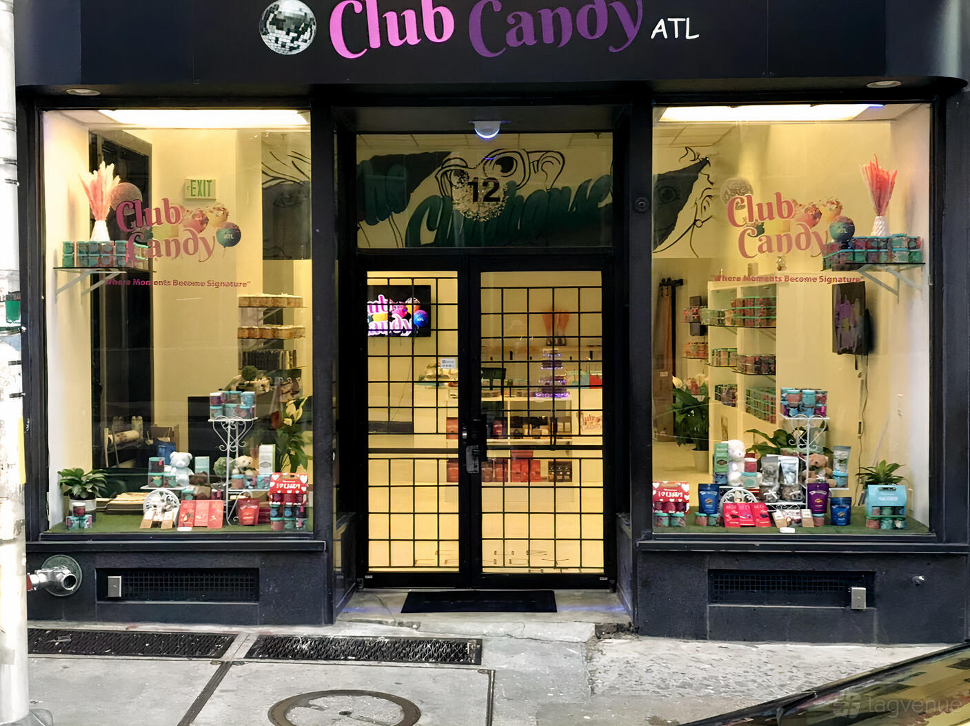 A versatile event space with large storefront windows, product displays, and potted plants at Club Candy ATL.