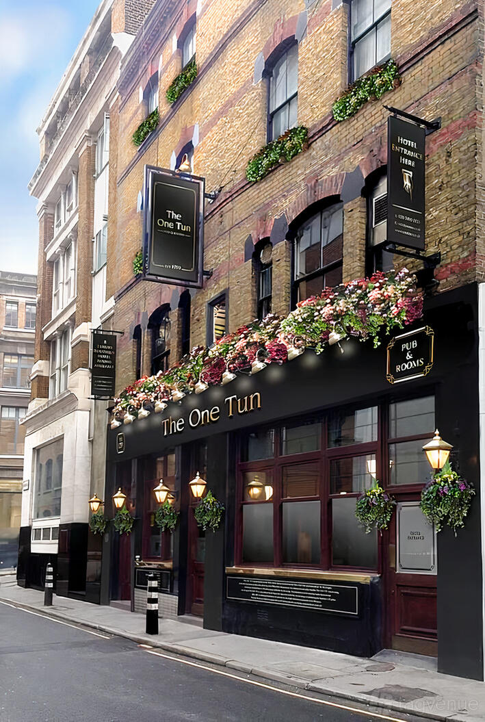 A historic pub with brick facade, flower boxes, and black signage at The One Tun Pub & Rooms.