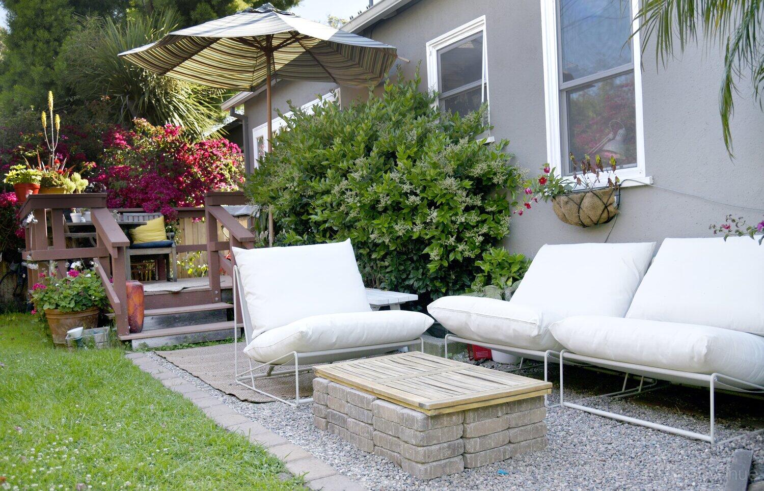 A house with cushioned outdoor seating, a small brick coffee table, and a shaded deck at Venice Fashion Shoot Home.