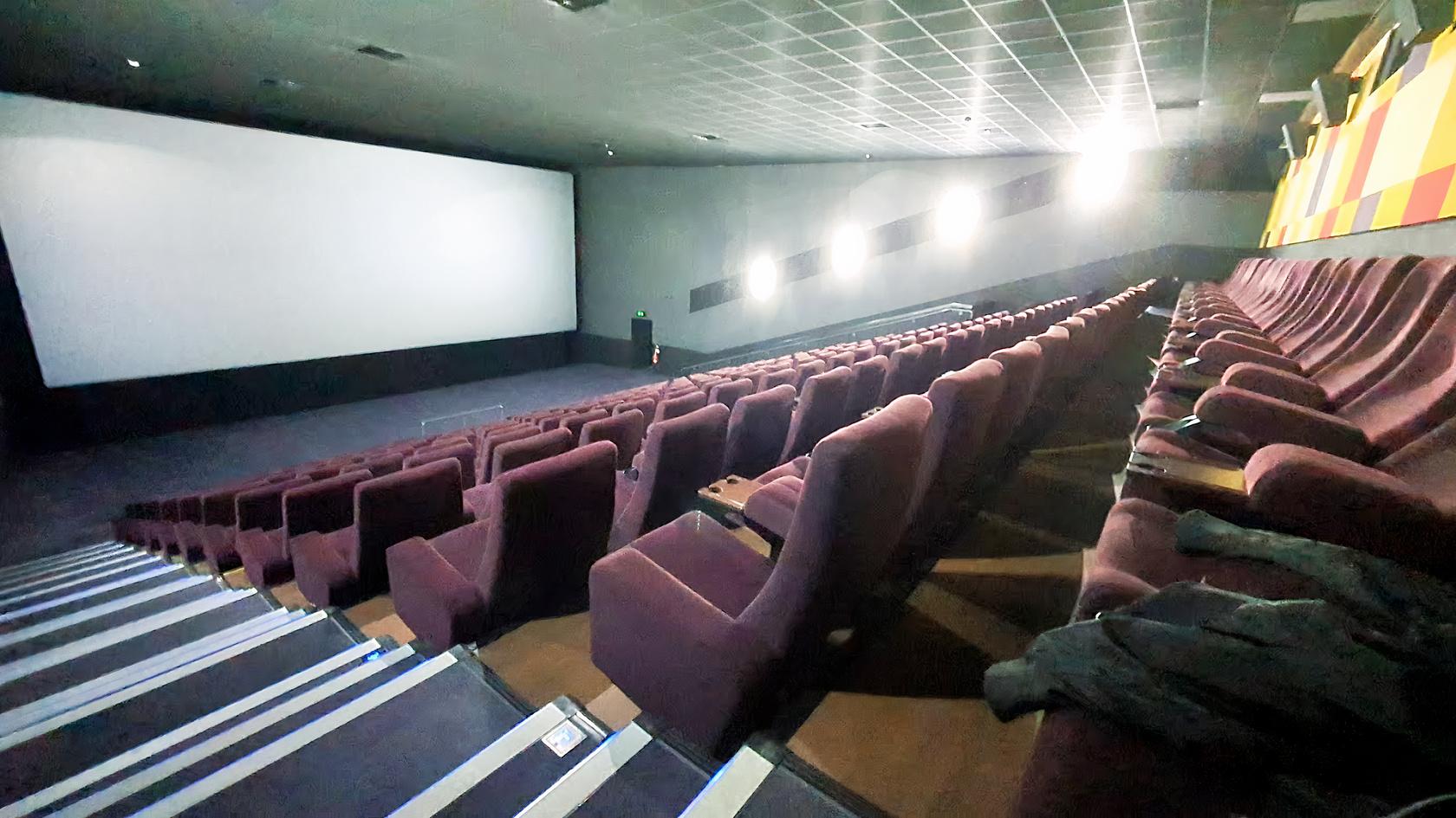 An auditorium with tiered plush seating facing a large projection screen at The Light Cinema - Walsall.