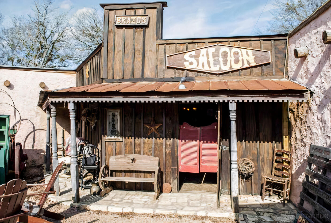 A rustic event venue with wooden saloon-style facade, tin roof, and vintage décor at Chisholm Trail Rustic Venue.