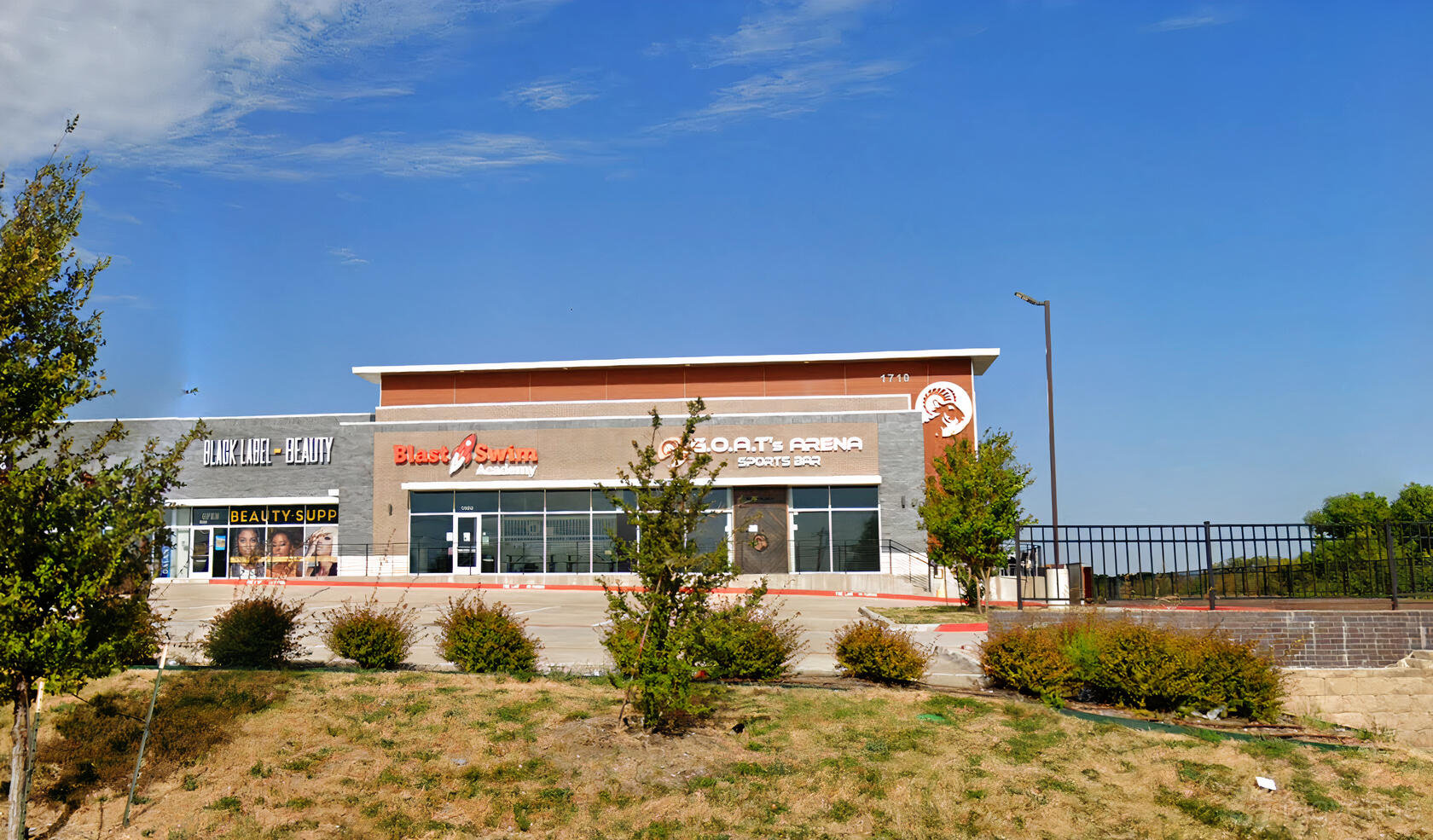 A pub and sports bar with a modern facade, brick detailing, and outdoor signage at GOATs Arena Sports Bar.