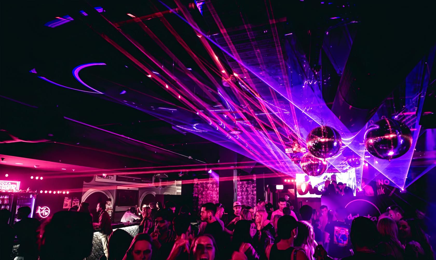 A nightclub event space with colorful laser lights, disco balls, and a lively dance floor at Dakota Nightclub.