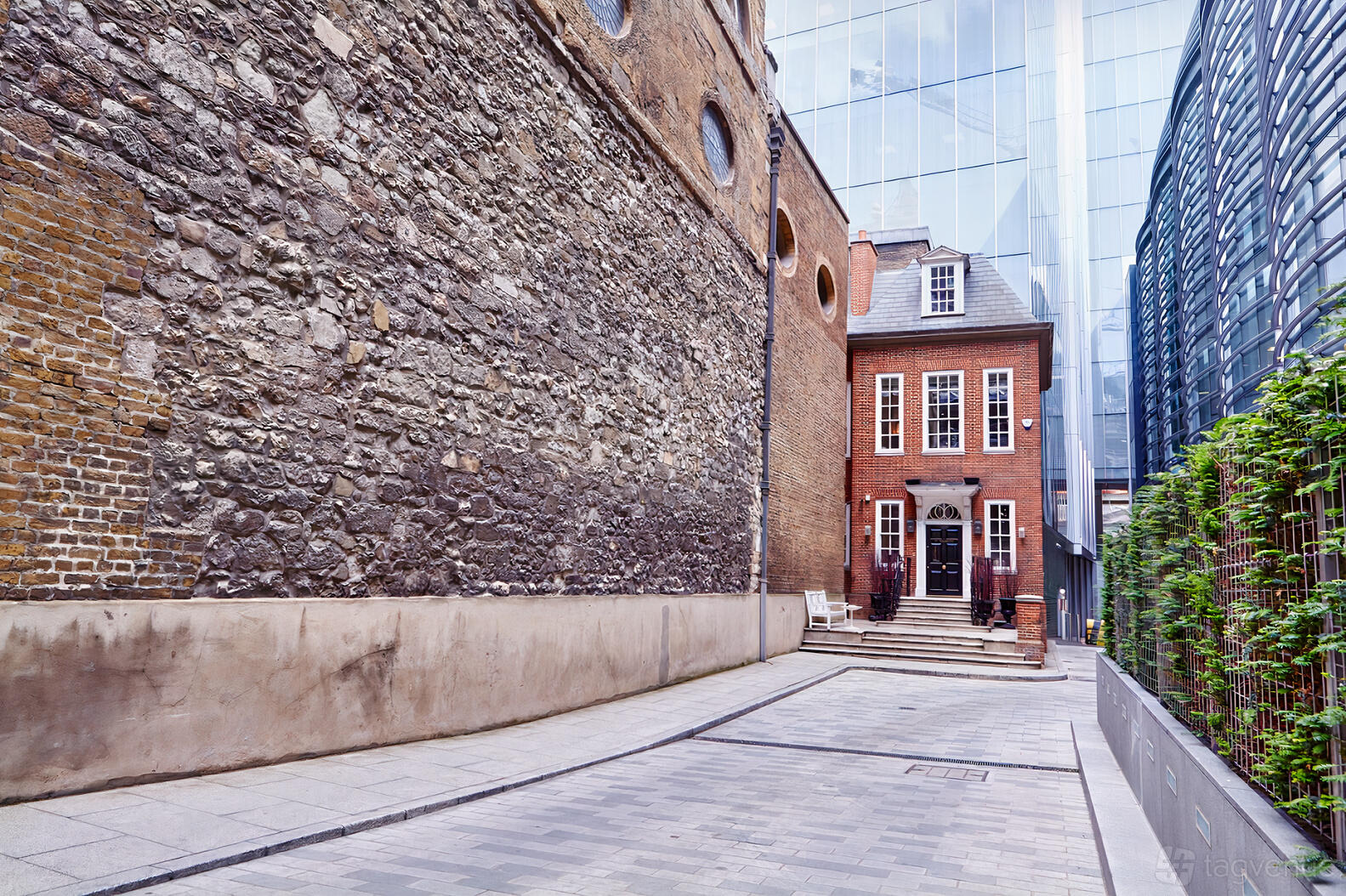 A historic building with red brick facade, arched windows, and stone walls at The Walbrook Club.