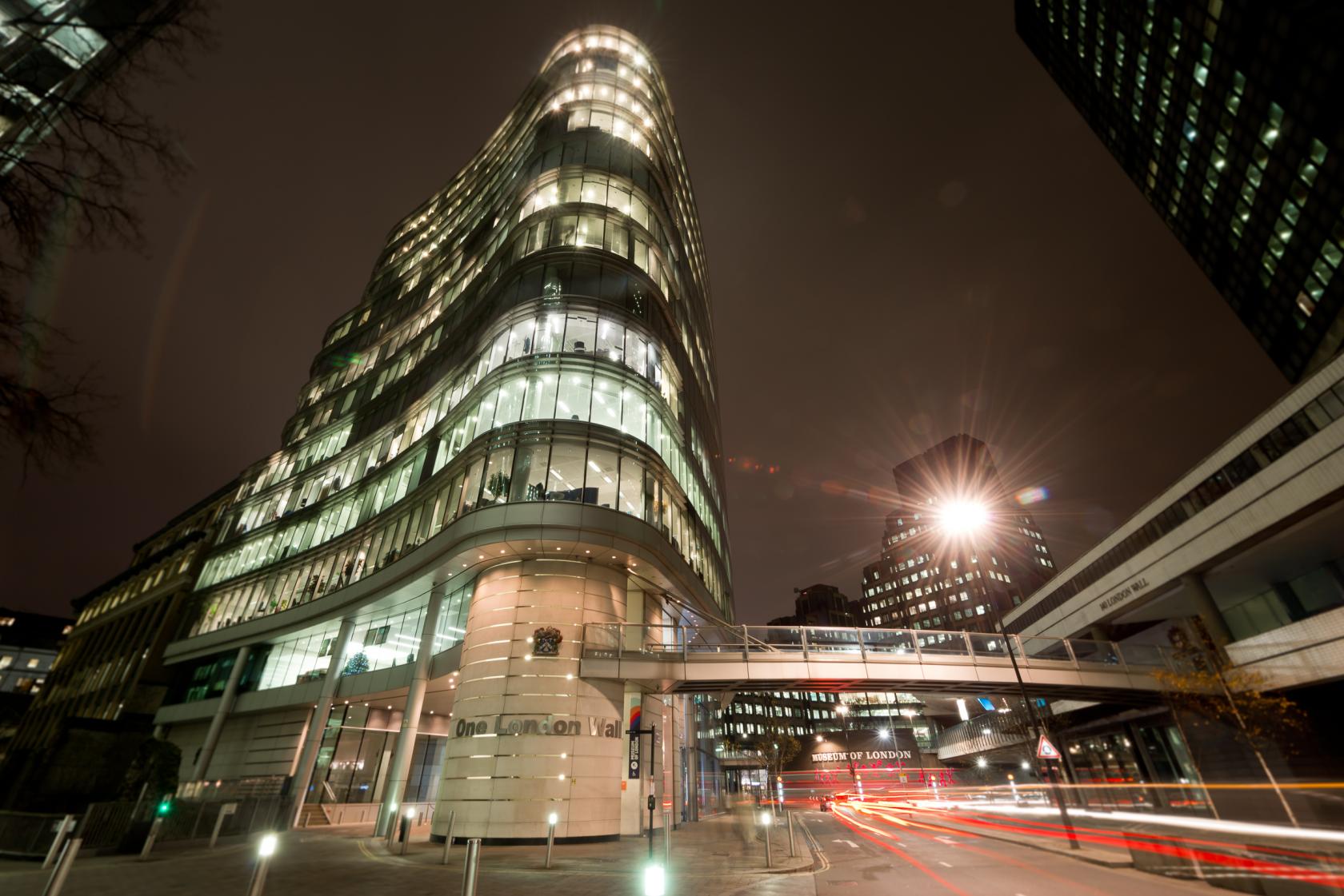 A modern hall with a curved glass facade and illuminated walkways at Plaisterers' Hall.